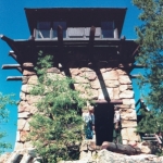 Two people standing in front of a stone tower.