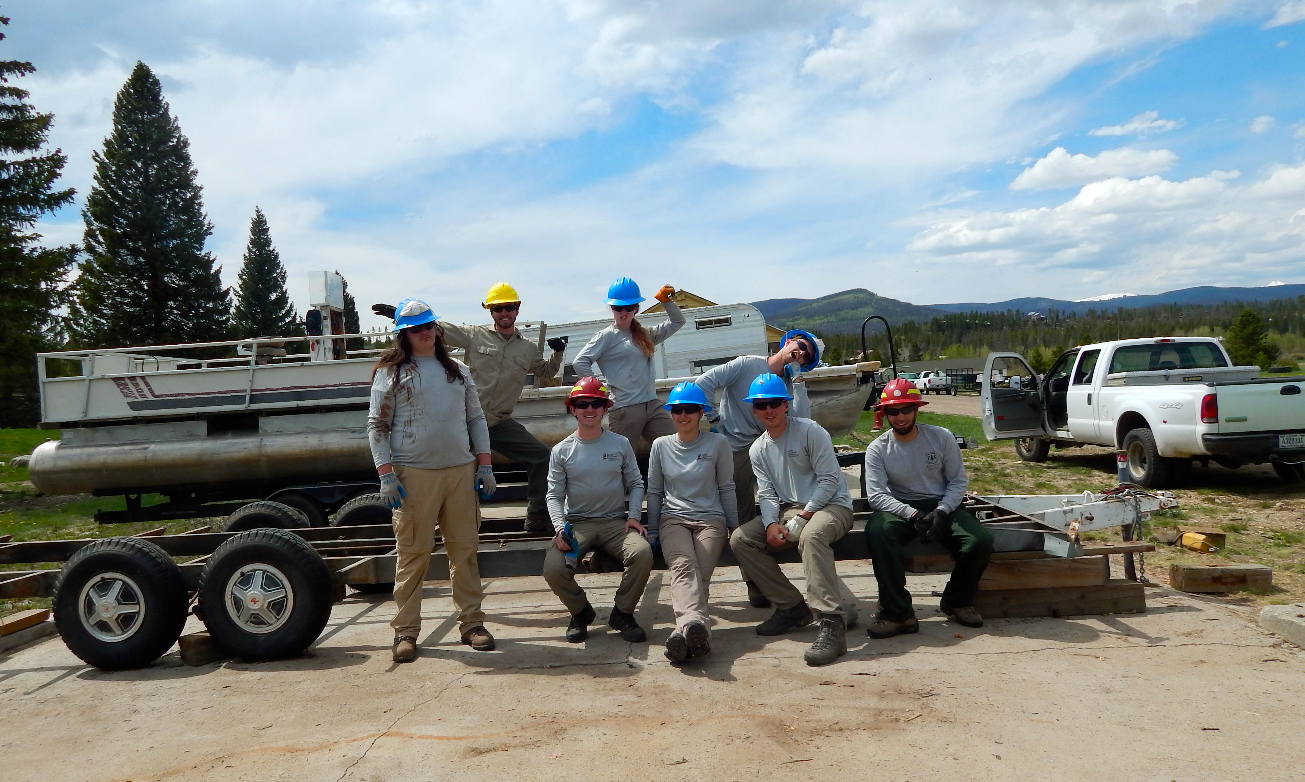 Workers sitting on a trailer posing for a picture