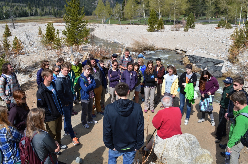 A group of people standing around a stream.