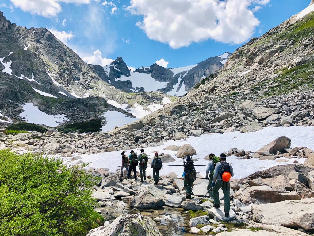 A group of hikers on a rocky trail in the mountains.