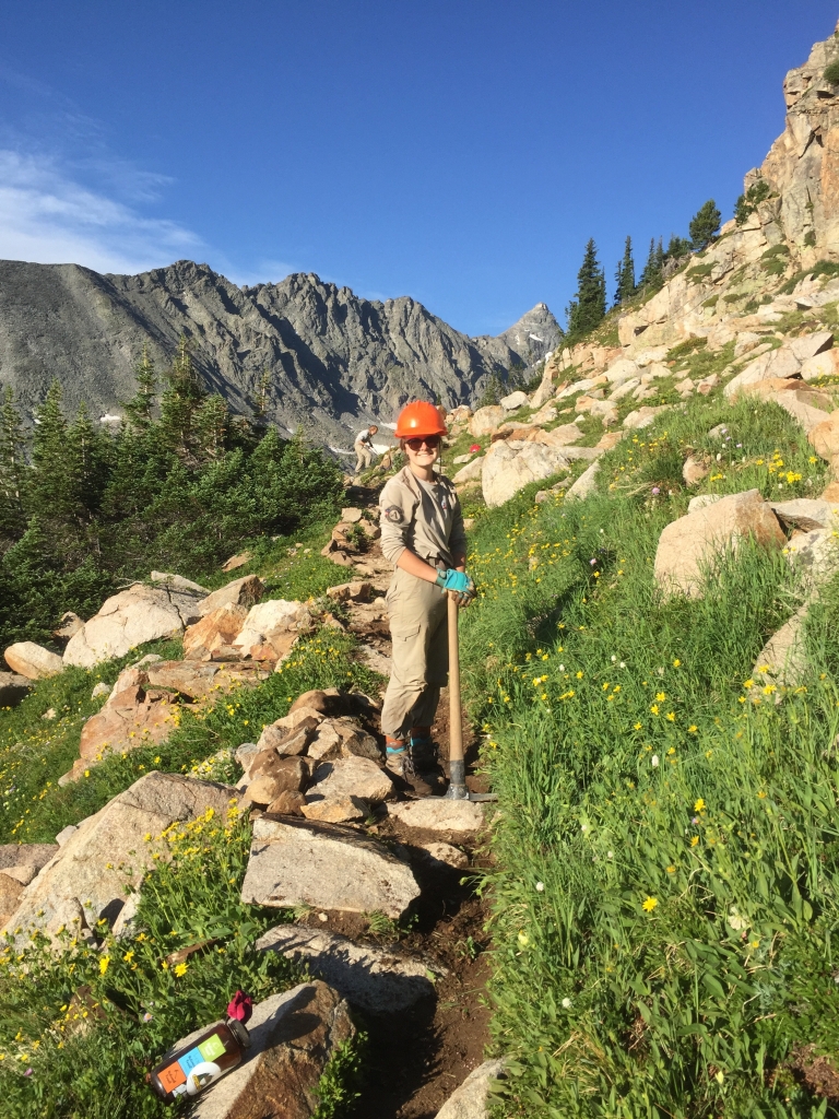 A hiker on a trail in the mountains.