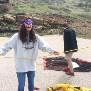Blindfolded woman laughing with a man in the background