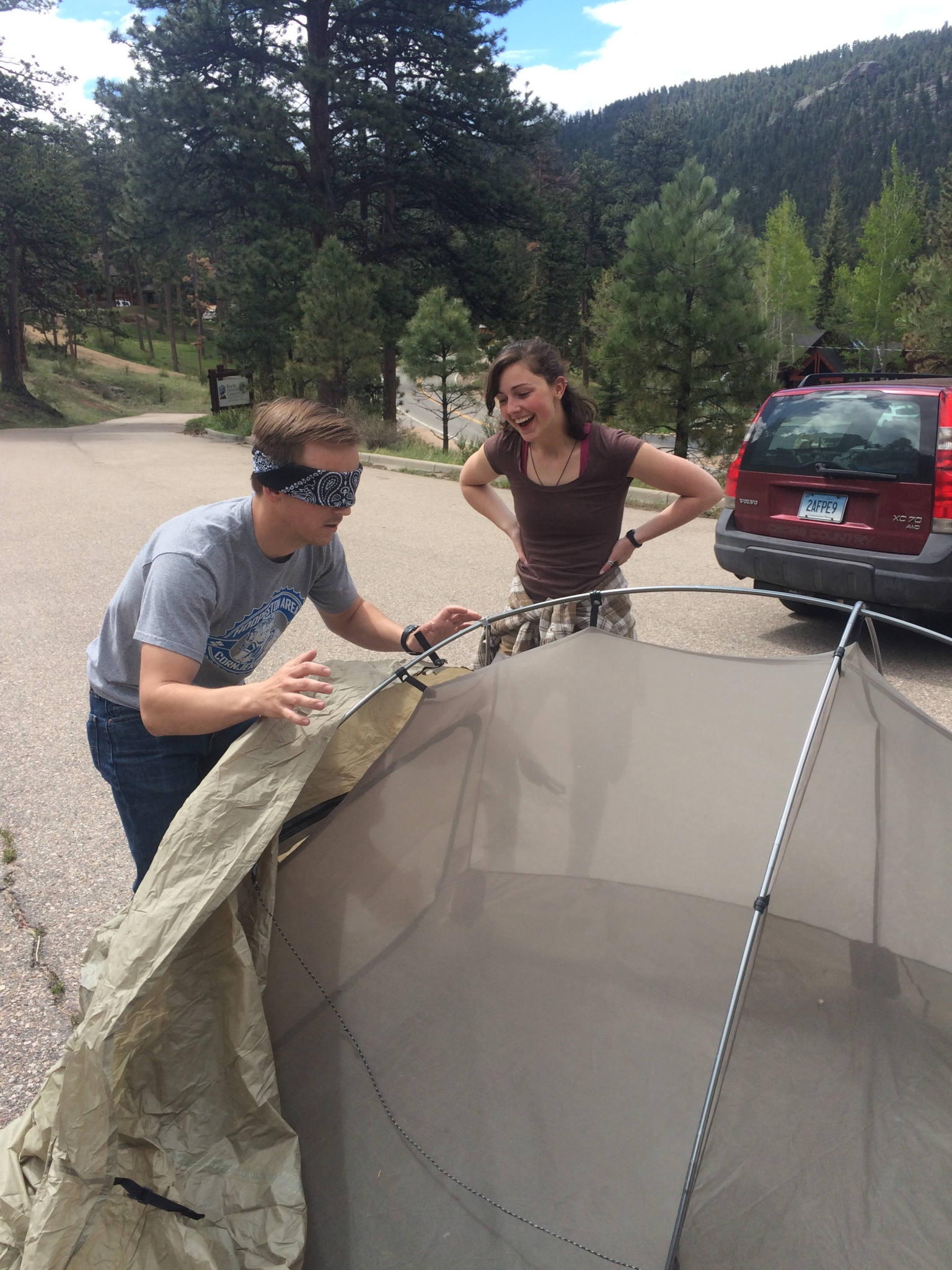 Blindfolded man setting up a tent