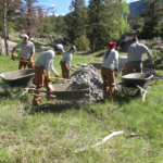 A group of people with wheelbarrows.