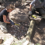 A group of people working on a pile of rocks.