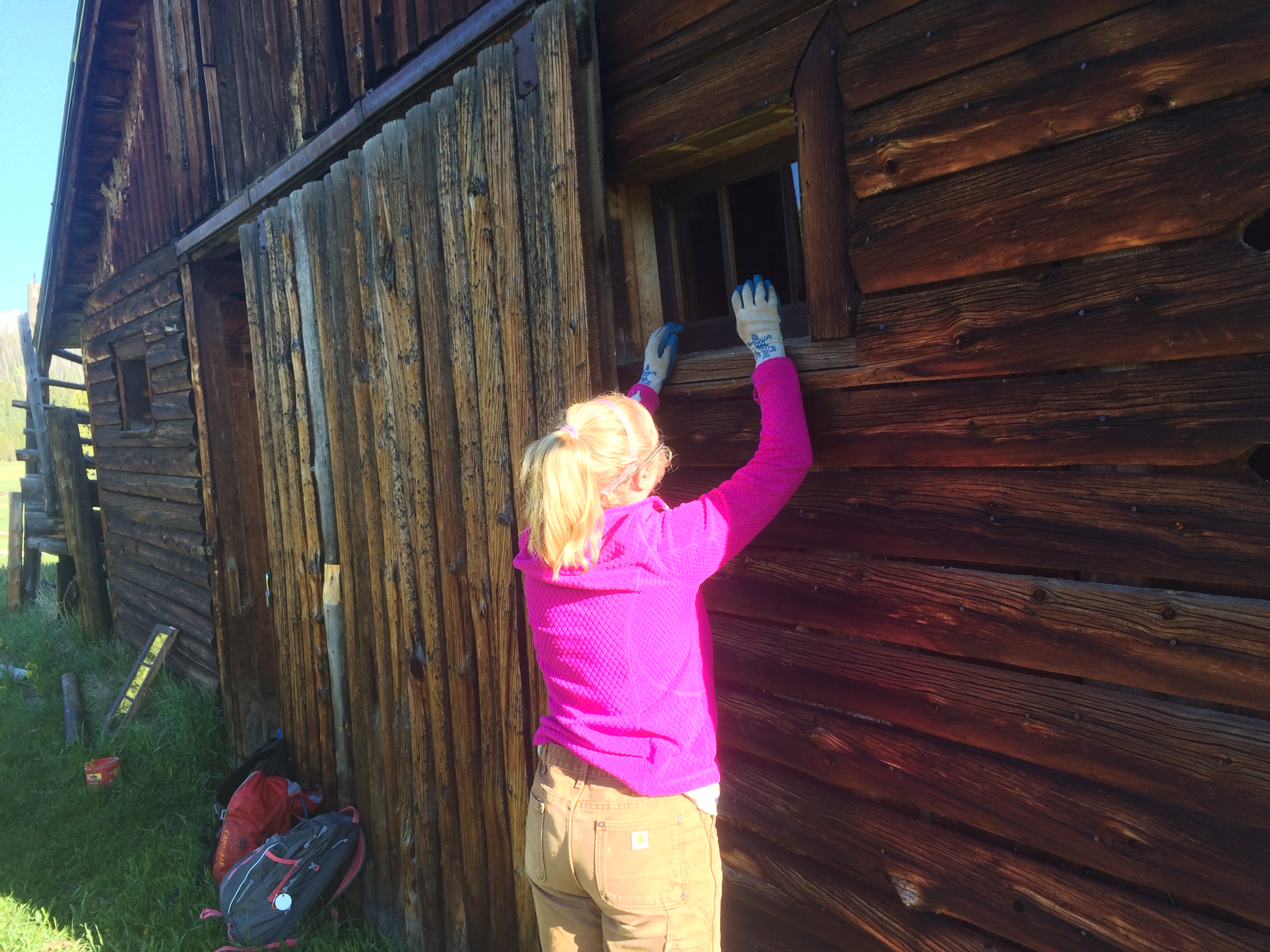Woman replacing a window of a barn