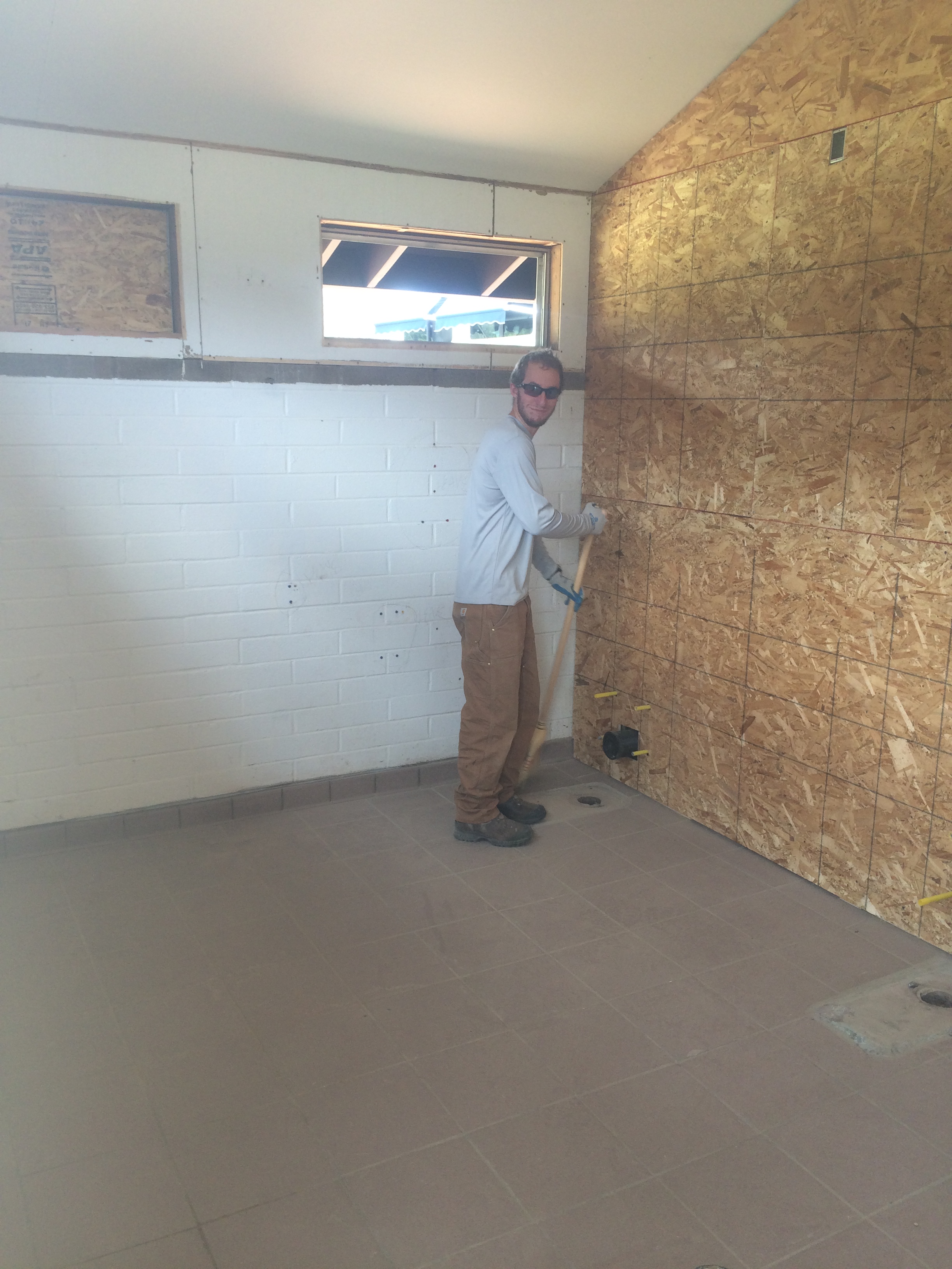 A man stands in a partially renovated room