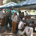 A group of people sitting under a tent.
