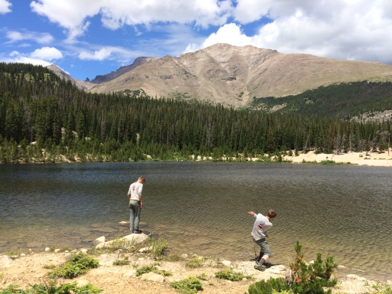 Two people by a mountain lake