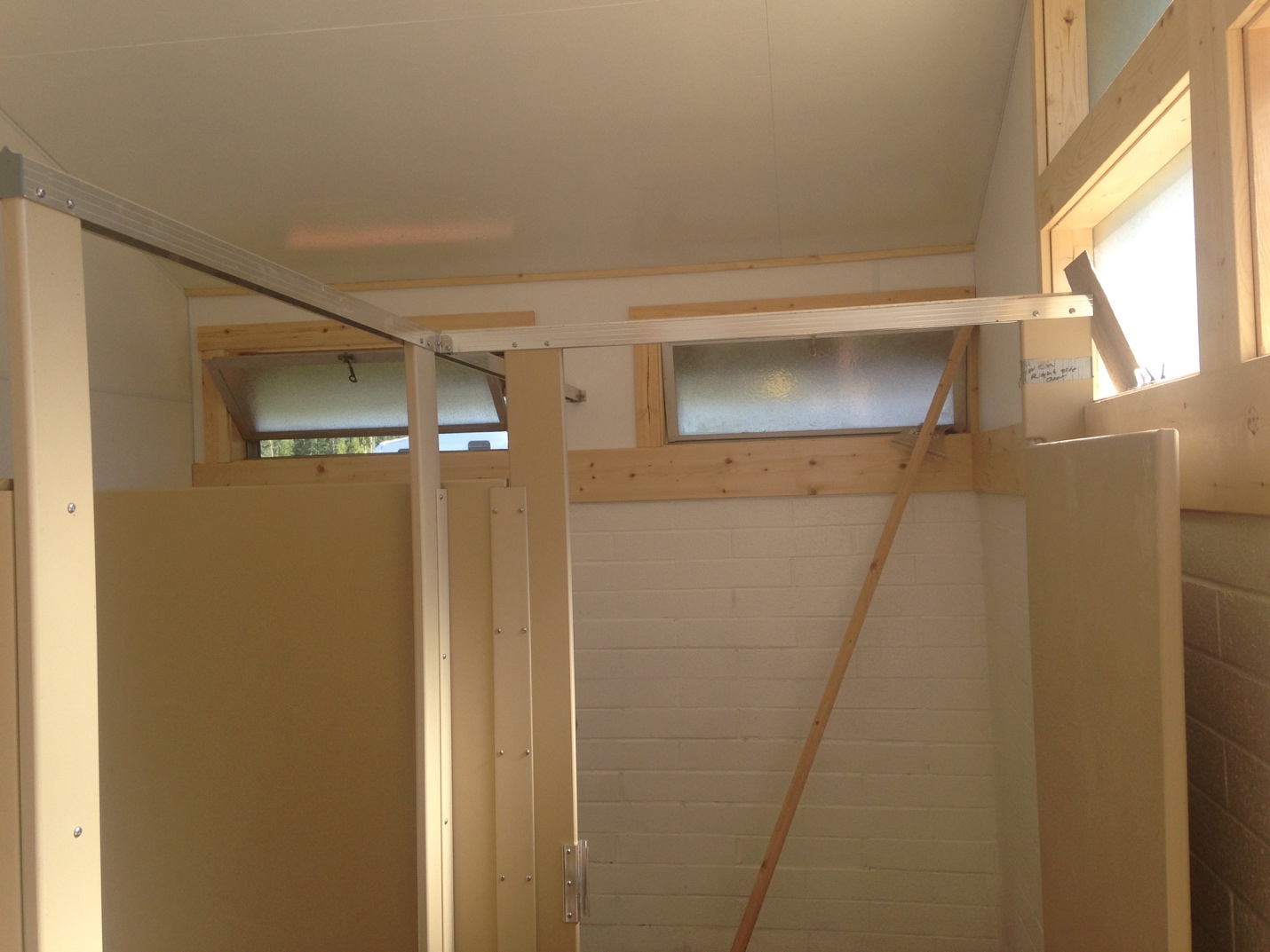 Interior of a building under construction with exposed wooden beams, unfinished walls, and a window