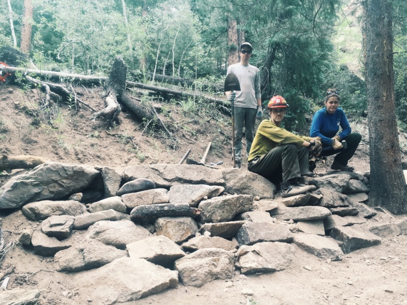 Three people resting in a wooded area