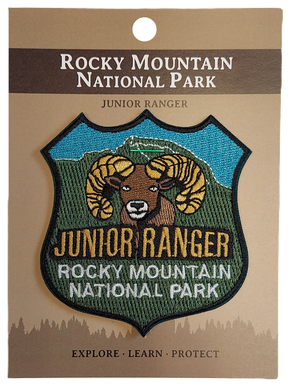 JR Ranger Junior Ranger patch featuring a ram design for Rocky Mountain National Park, presented on a brown card with "Explore • Learn • Protect.