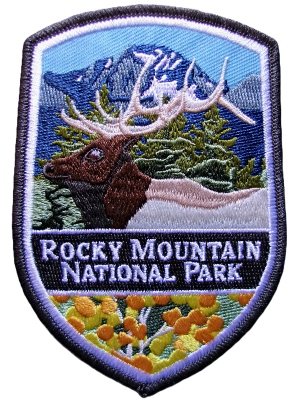 Embroidered "RMNP Patch" magnet portraying a deer, trees, mountains, and colorful flowers.