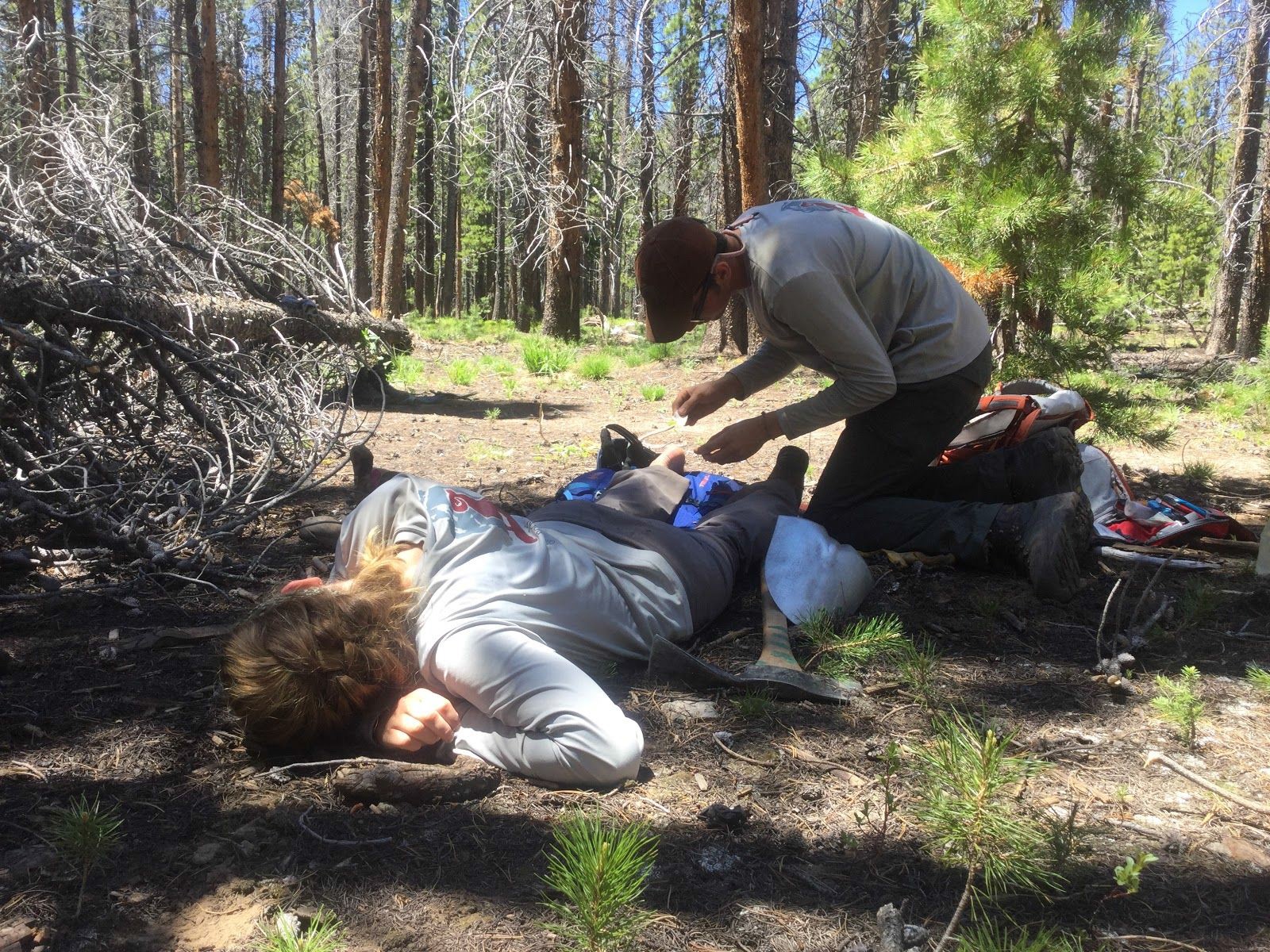 A first responder administers aid to an injured person lying on the ground