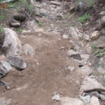 A dirt trail with a shovel in it.