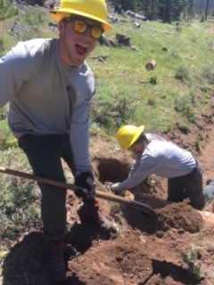 Two people digging in soil outdoors