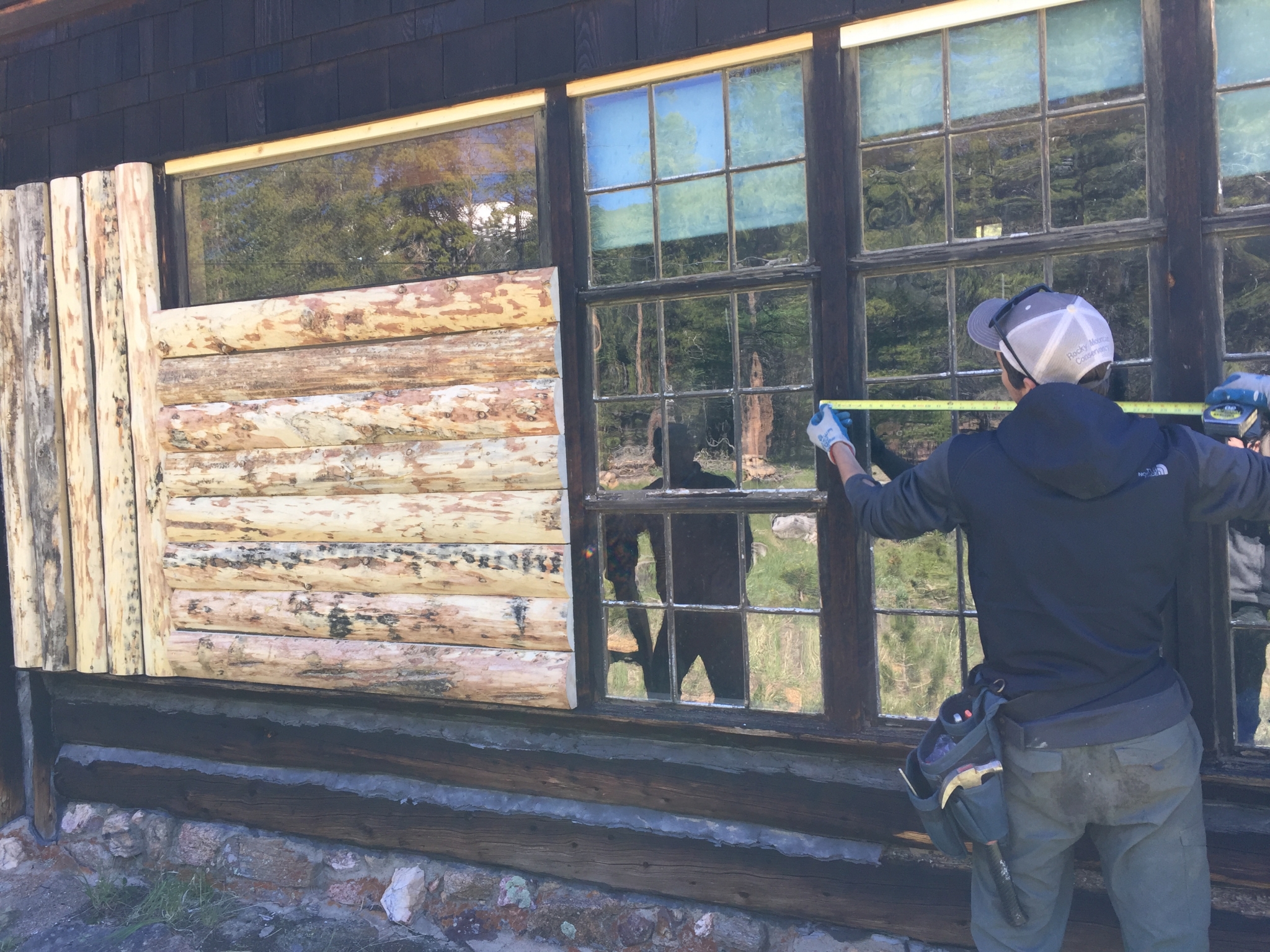 A person measuring the windows of the cabin
