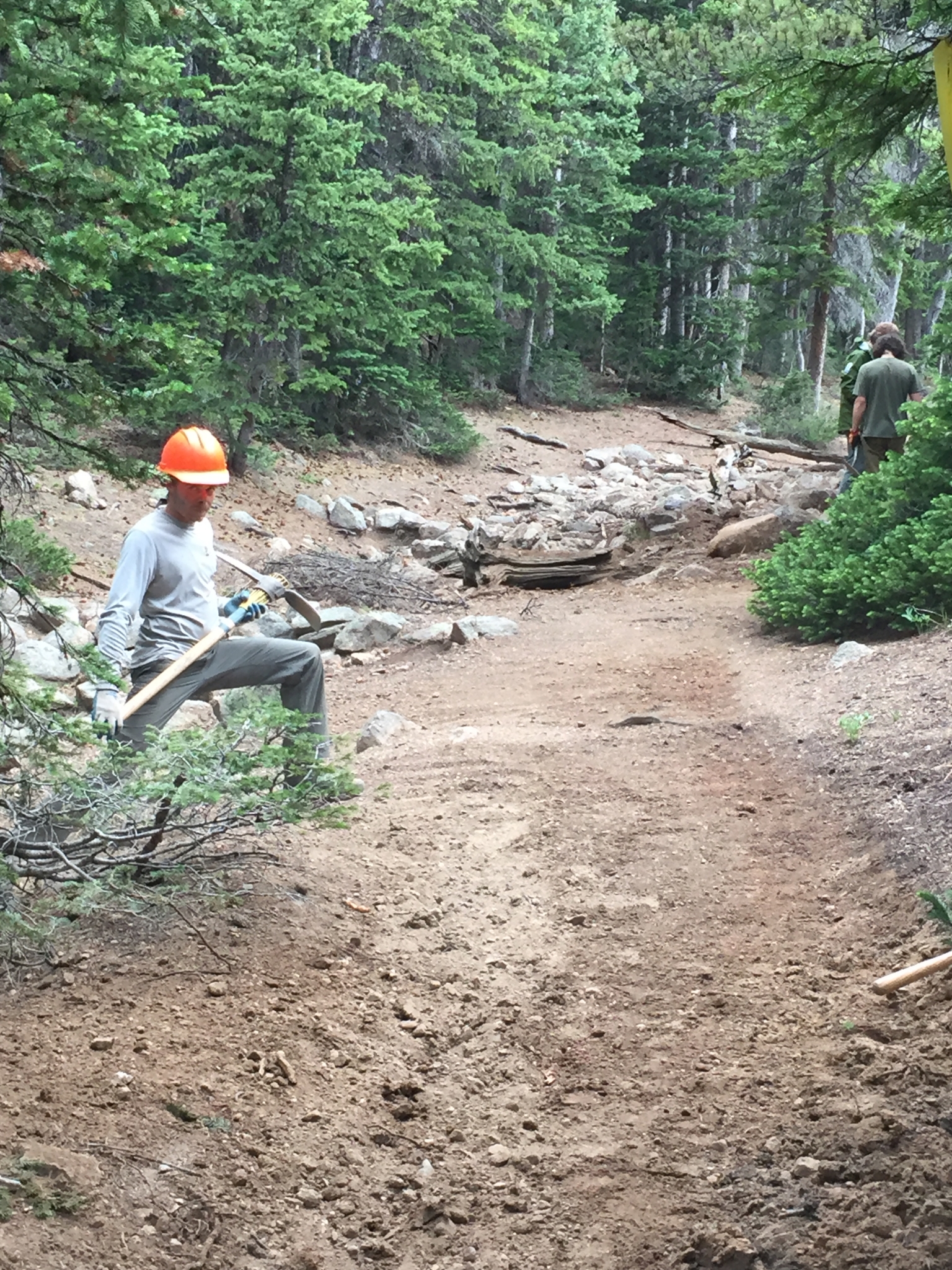 A person wearing an orange helmet preparing to dig