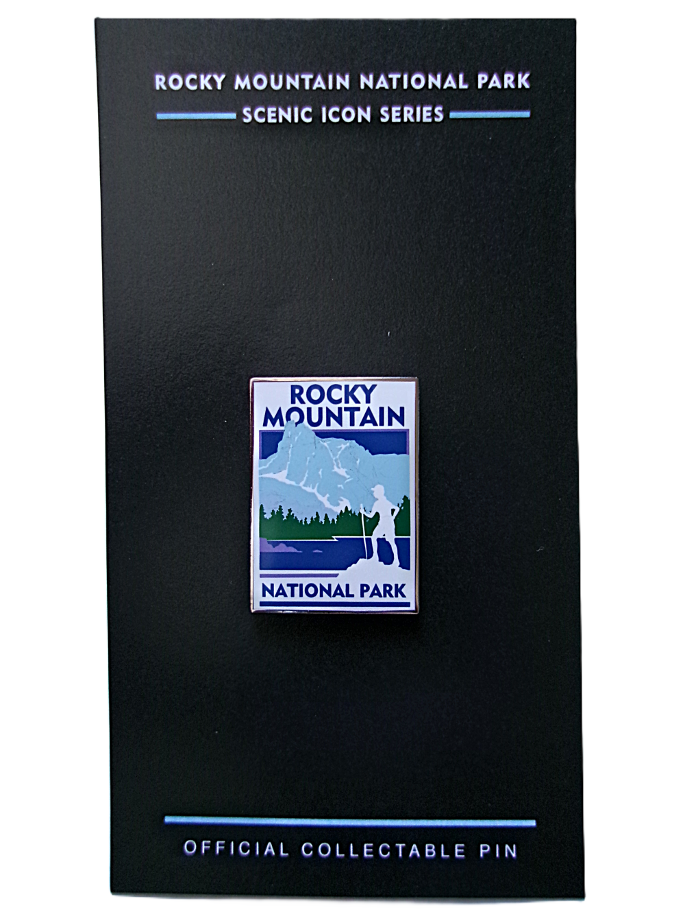A collectible "RMNP Scenic Icon Series" pin featuring mountains and trees is displayed on a black card.