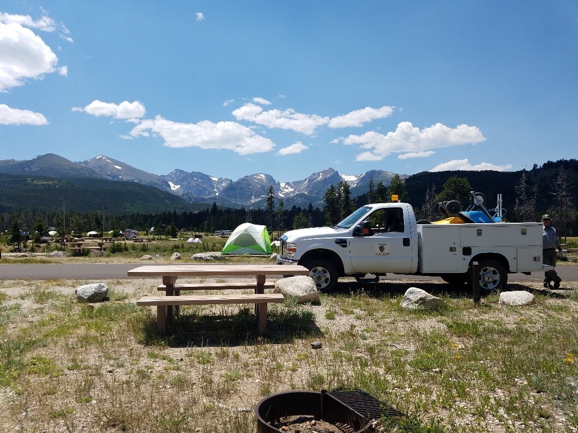 A utility truck parked near a campsite with tents
