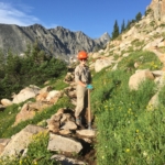 A hiker on a trail in the mountains.