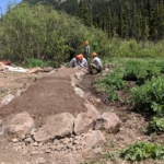 A group of people working on a trail in the mountains.
