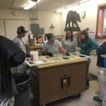 A group of people standing around a table.