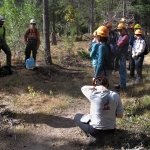 A group of people standing in a wooded area.