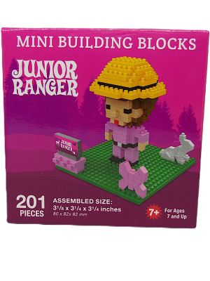 Box of "Junior Ranger Pink" mini building blocks with a figure, hat, sign, dog, and trees on a green base. Includes 201 pieces for ages 7+.