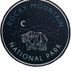 Circular "Sticker - RMNP Bear Constellation" featuring a geometric bear design beneath a starry sky with "Rocky Mountain National Park" text and crescent moon.