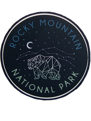 Circular "Sticker - RMNP Bear Constellation" featuring a geometric bear design beneath a starry sky with "Rocky Mountain National Park" text and crescent moon.