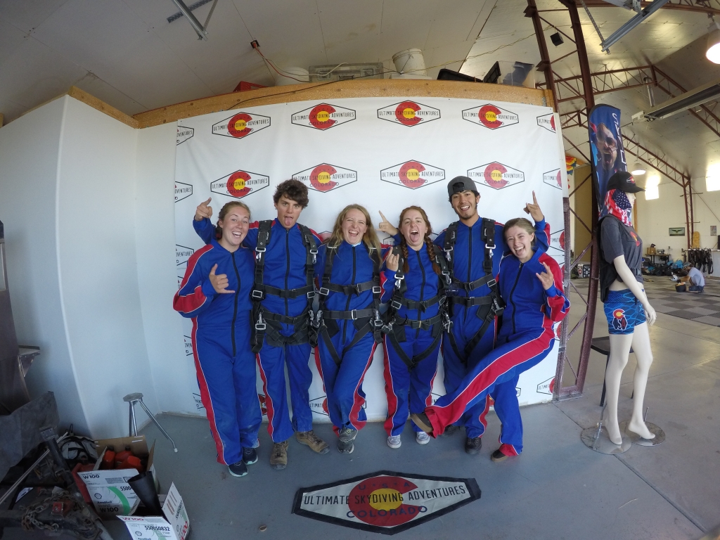 A group of people in blue jumpsuits posing for a photo.
