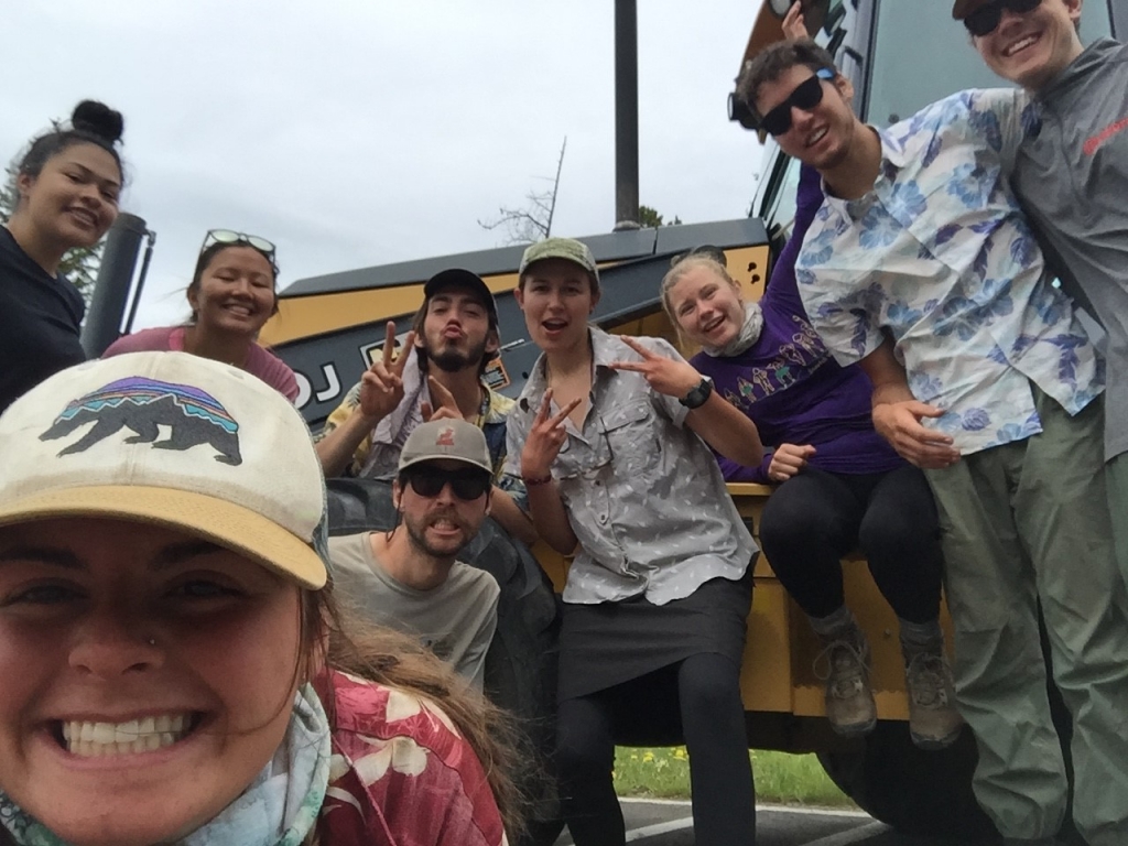 A group of people posing for a photo in front of a bus.