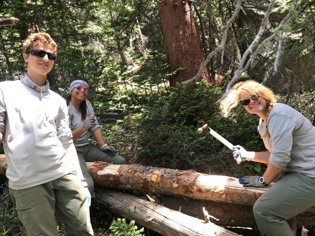 A group of people posing for a photo in the woods.