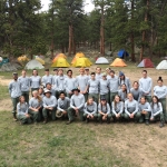 A group of people posing in front of tents.