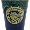 Navy and green shot glass featuring a "Rocky Mountain National Park" emblem with a pika illustration.