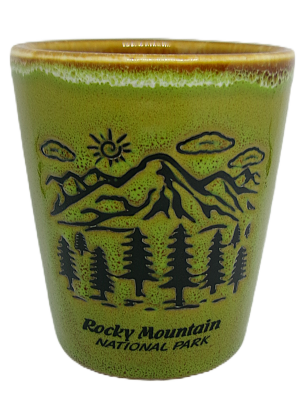 Green ceramic shot glass with "Rocky Mountain National Park" text and black illustrations of mountains, trees, and sky.