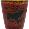 Red Shot Glass featuring a black elk silhouette, "Rocky Mountain National Park" text, and adorned with mountainous and star-like designs. Product: Shot Glass - RMNP Solid Elk Scene.