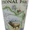 A shot glass featuring a map design with an elk, flowers, and the text "RMNP Map Blue Xplorer.
