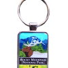 The RMNP Collectors Elk Keychain displays an elk with antlers among blue mountains and green trees labeled "Rocky Mountain National Park.