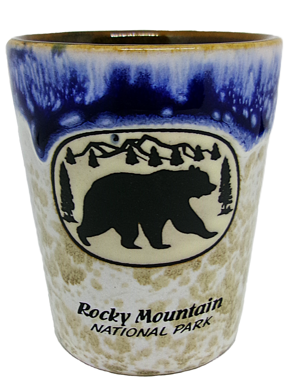 Blue Bear Shot glass with a bear silhouette, mountain, and tree design. Text reads "Rocky Mountain National Park" with a two-tone blue upper section and textured earthy lower section.