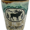 Green Tan Elk Shot glass featuring a silhouette of an elk and trees with "Rocky Mountain National Park" text against a green and brown glaze backdrop.