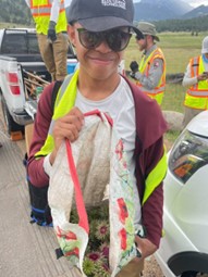 A girl holding a bag of flowers in front of a truck.