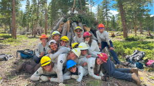 A group of people posing in front of a fire shack.