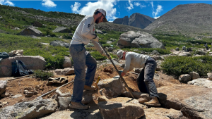Two men installing riprap pavers