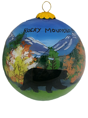 The Ornament - RMNP Fall Bear Scene Glass features a round design with a bear, colorful trees, and snow-capped mountains labeled "Rocky Mountain.