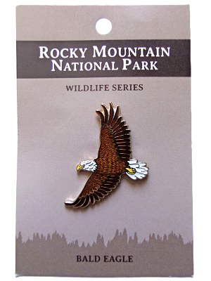 A pin showcasing a bald eagle in flight on a card titled "RMNP North American Wildlife Series.