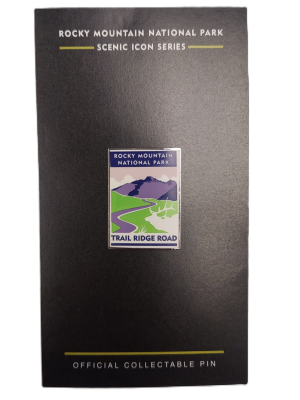A collectible pin named "Pin - RMNP Trail Ridge Road" is featured on black packaging.