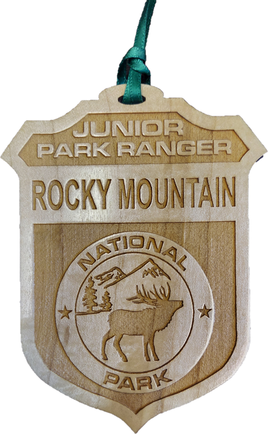 Junior Ranger Badge An ornament, named the "RMNP Junior Ranger Badge," features a wooden design with the words "Junior Park Ranger Rocky Mountain National Park" and an engraved image of a deer and trees.