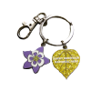 Keychain - Aspen and Columbine: Features a silver ring and clasp with two charms—a purple flower and a yellow leaf inscribed with "Rocky Mountain National Park.